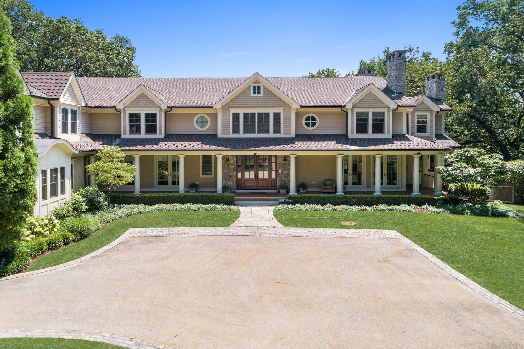 Luxury great room with stone fireplace and dramatic windows